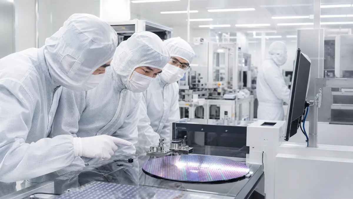 Ingénieurs observant des wafers dans une salle blanche de semi-conducteurs